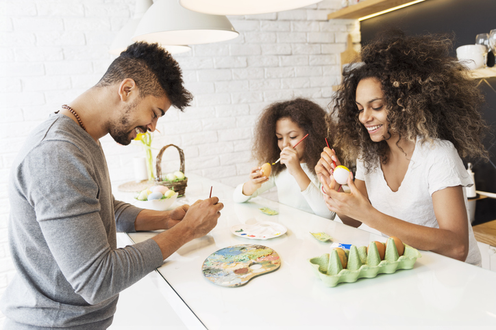 Happy African American family coloring Easter eggs